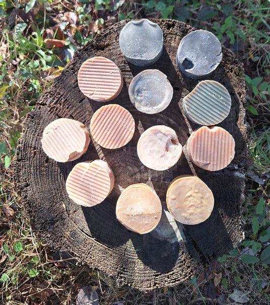 Collection of perfectly unique goat milk shampoo on a tree stump with a natural outdoor background